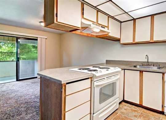 Milton Apartments - Autumn Village Apartments - Living Room, Kitchen, and Deck