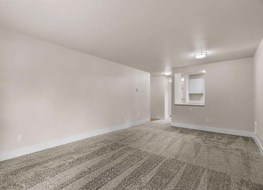 an empty living room with carpet and white walls at Bellamy Park Apartments , Lakewood