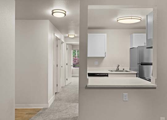 a kitchen with a sink and a refrigerator in a house at Bellamy Park Apartments , Lakewood, 98498