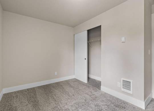 an empty bedroom with a closet and a carpeted floor at Bellamy Park Apartments , Lakewood, CA, 98498