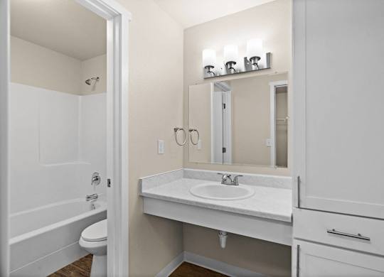 a bathroom with a sink and a mirror and a shower at Bellamy Park Apartments , Lakewood, CA