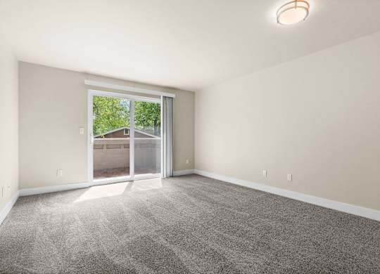 an empty living room with a large window and carpet at Bellamy Park Apartments , Lakewood, CA, 98498