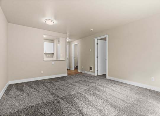a living room with carpet and a door to a kitchen at Bellamy Park Apartments , Washington
