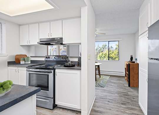 a kitchen with white cabinets and stainless steel appliances at The Verandas, Tacoma