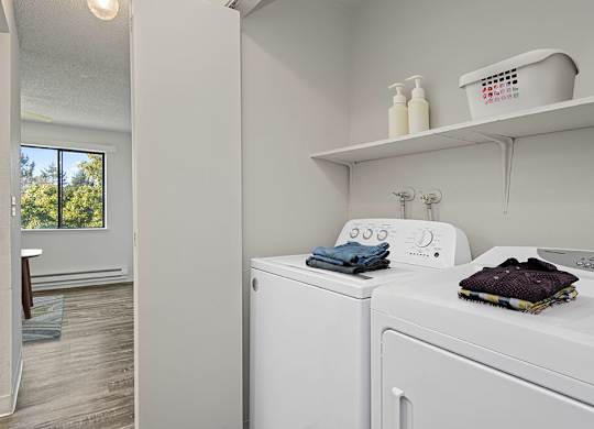 a white laundry room with a washer and dryer and a window at The Verandas, Tacoma, WA