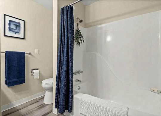 A blue towel hangs on a towel rack in a bathroom.
