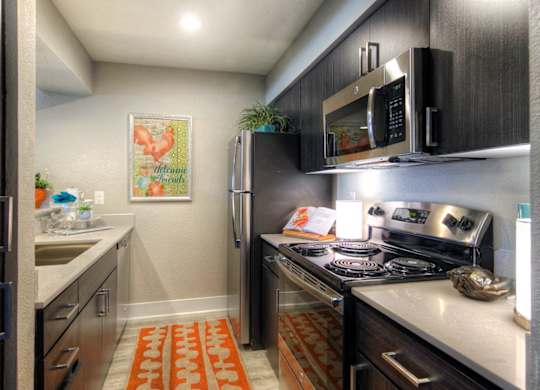 A kitchen with a stove top oven and a refrigerator.