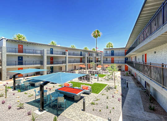 A sunny day at a resort with a pool and a patio.
