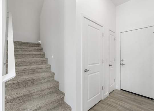 A staircase with a carpeted runner and a white railing.