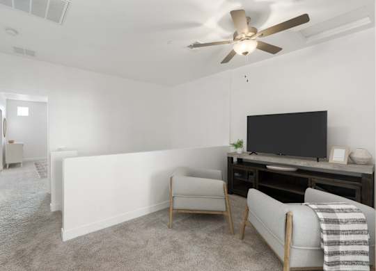 A living room with a television, a chair, and a blanket.