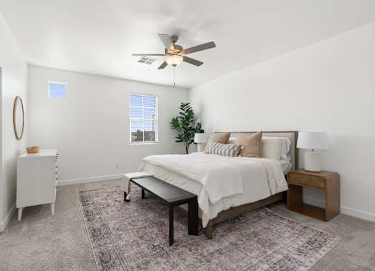 A bedroom with a bed, nightstand, and a rug.