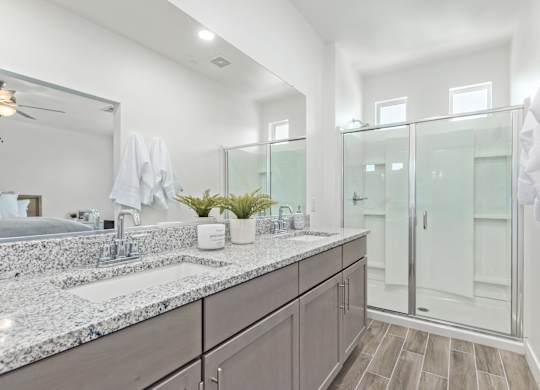 A bathroom with a marble countertop and a large mirror.