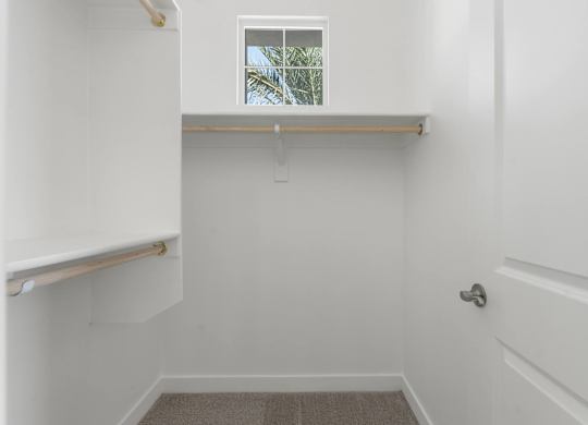 A white bathroom with a window and a door.