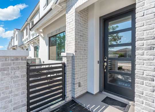 A modern house with a black gate and a glass door.