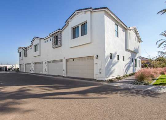 A large white house with a garage door and a driveway.