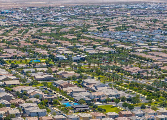 A bird's eye view of a residential neighborhood with houses and swimming pools.