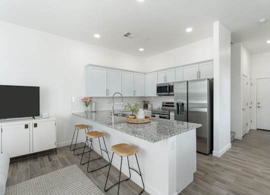 A kitchen with white cabinets and a granite countertop.