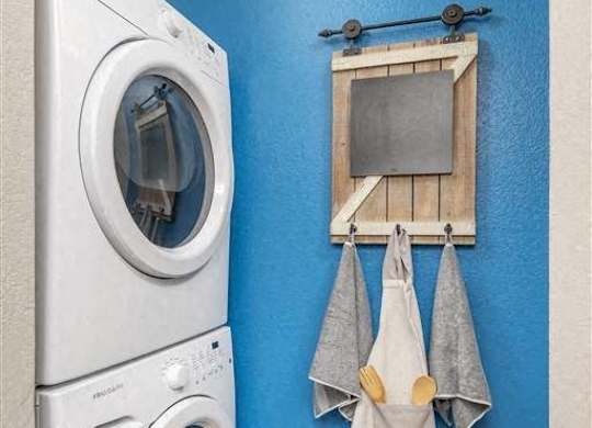 A washing machine is placed next to a dryer in a laundry room.