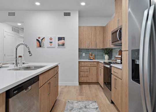 A modern kitchen with wooden cabinets and stainless steel appliances.