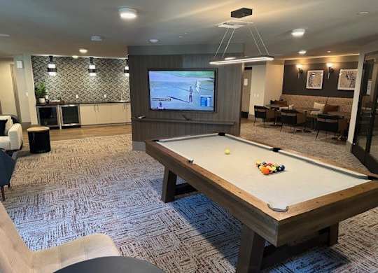 A pool table with a television in the background.