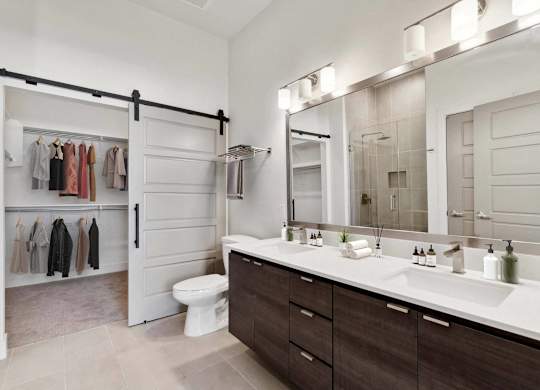 A bathroom with a white counter top and a white toilet.