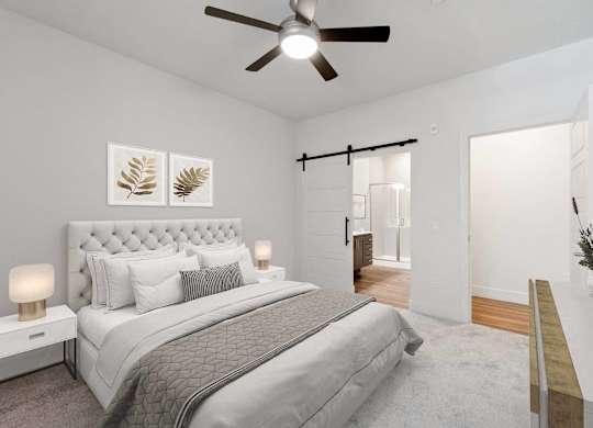 A bedroom with a large bed and a ceiling fan.