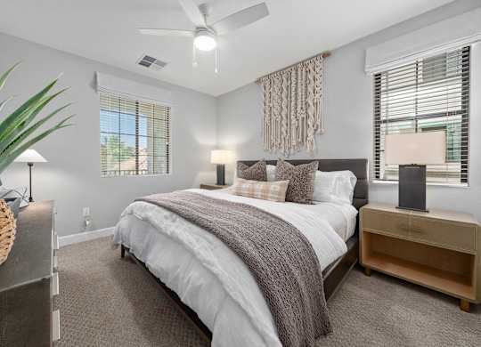 A bedroom with a large bed and a ceiling fan.