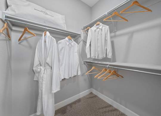 A row of white shirts hanging on a rack.