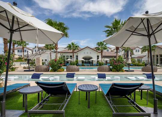 A poolside area with lounge chairs and umbrellas.