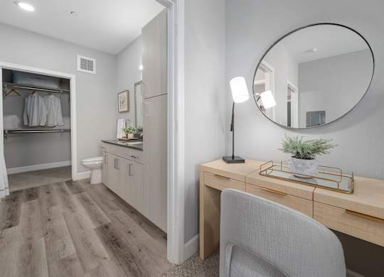 A room with a desk, chair, and a mirror.