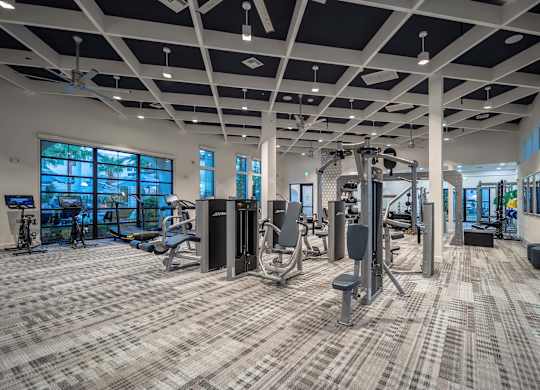 A spacious gym with a variety of equipment and a carpeted floor.