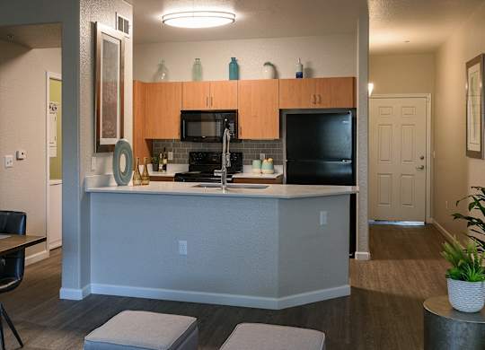 A kitchen with a black counter top and a white island.