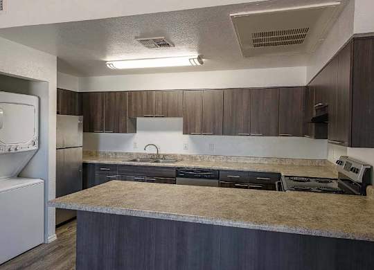 A kitchen with a refrigerator, sink, and countertop.