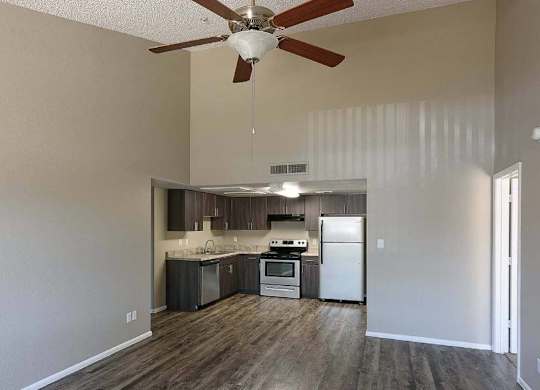 A kitchen with a refrigerator, oven, and sink is visible from the living room.