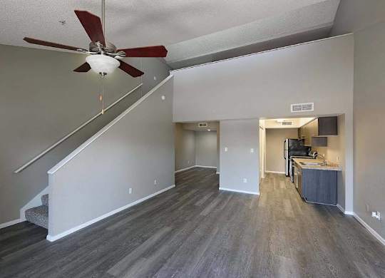 A room with a staircase and a ceiling fan.
