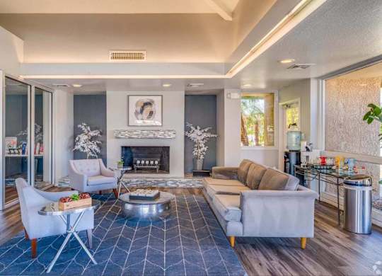 A modern living room with a fireplace and a blue rug.