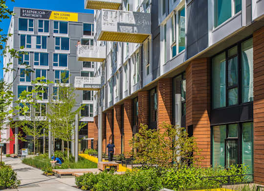 A modern apartment complex with a mix of brick and glass buildings.