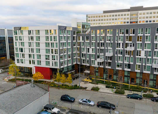 A parking lot with cars and apartment buildings.