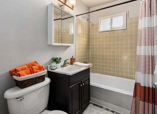 A bathroom with a white toilet, a sink, and a bathtub.