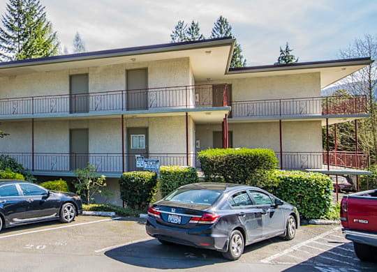 an apartment building with cars parked in front of it