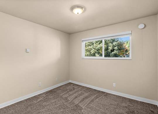 an empty room with carpet and a window