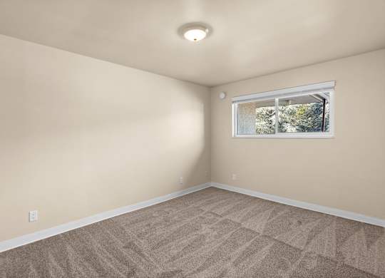 an empty room with carpet and a window