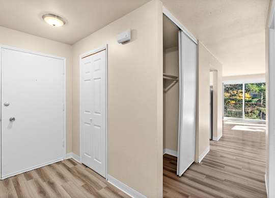 an empty room with doors to a closet and a window