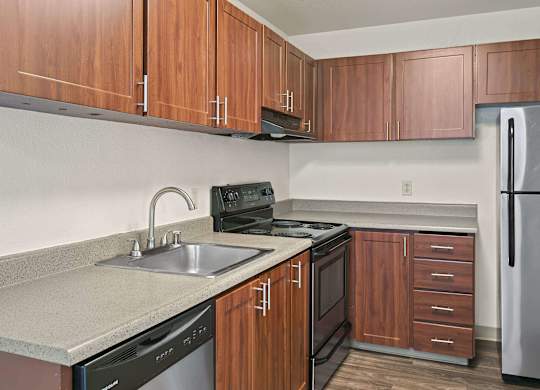 A kitchen with brown cabinets and a black stove top oven. at Brookstone, Washington, 98198