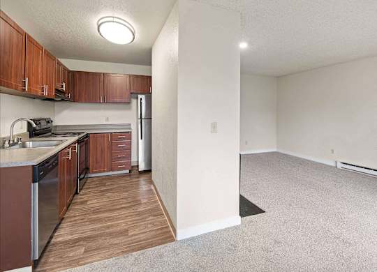 A kitchen with wooden cabinets and a refrigerator. at Brookstone, SeaTac, WA