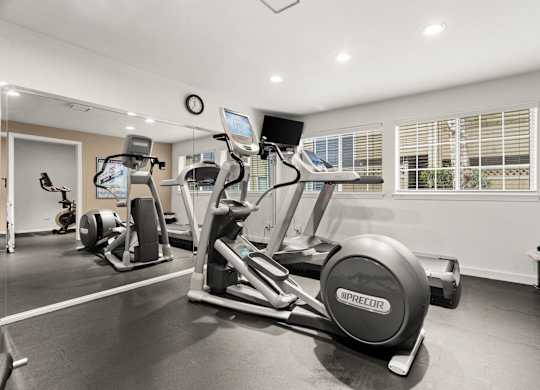 A gym with a treadmill, exercise bike, and other equipment.