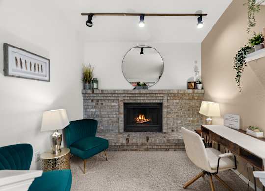 A living room with a fireplace and a green chair.