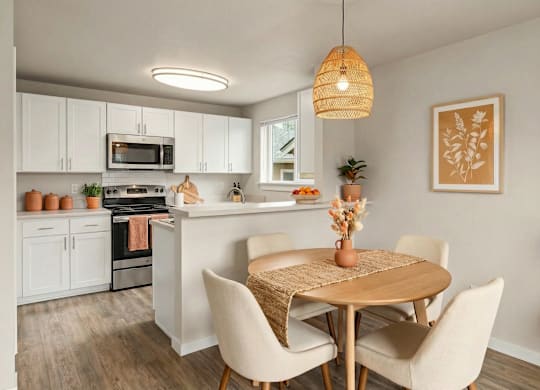 A kitchen with a table and chairs in the foreground.
