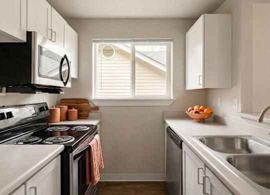 A kitchen with a black stove top oven and white cabinets.