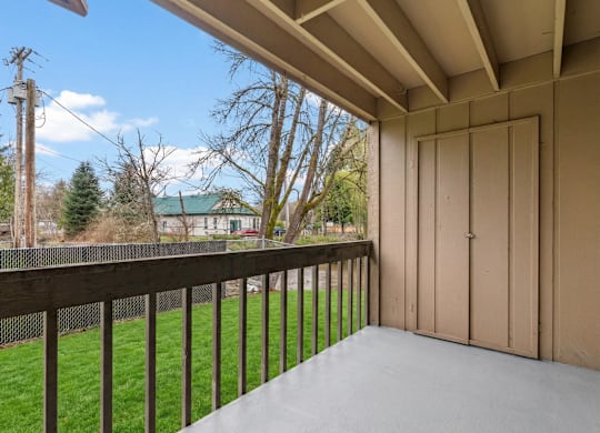 A balcony with a wooden railing and a sliding door.